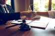 © wutzkoh - Lawyer is currently shaking hands with the client about the success in resolving the case.