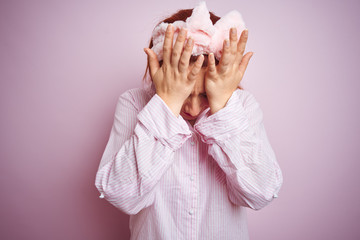 Sticker - Young beautiful redhead woman wearing pajama standing over pink isolated background suffering from headache desperate and stressed because pain and migraine. Hands on head.