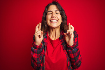 Wall Mural - Young beautiful woman wearing casual jacket standing over red isolated background shaking and freezing for winter cold with sad and shock expression on face