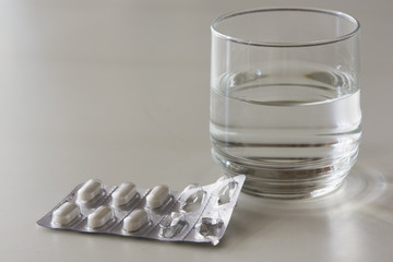 Medications and a glass of water on the table