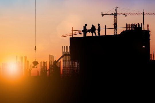 Silhouette of engineer and construction team working at site over blurred background for industry background with Light fair.Create from multiple reference images together