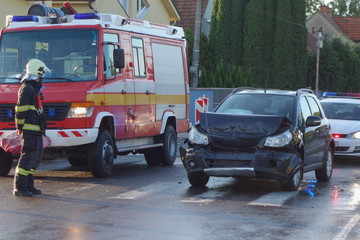 Wall Mural - Real event. Car accident. The car crashed at day on a wet road . Car accident over raining day in autumn time. Rescuers help with car accident.