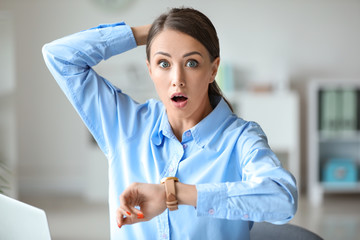 Wall Mural - Stressed young woman trying to meet deadline in office