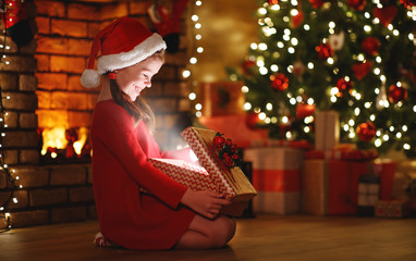 Wall Mural - happy laughing child girl with magic gift on christmas eve