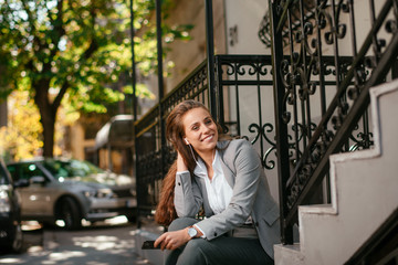 Young businesswoman outside. Beautiful businesswoman outdoors listening music. 