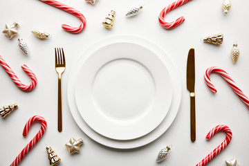 Wall Mural - top view of christmas table setting on white background with festive decoration and candies