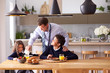 © Monkey Business - Children Wearing School Uniform Eating Breakfast As Father Gets Ready For Work