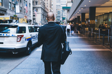 Wall Mural - African American worker walking down street