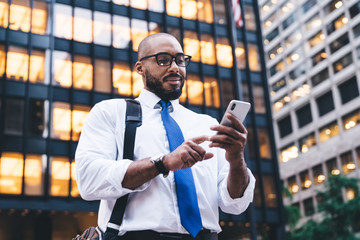 Ethnic bearded executive using smartphone