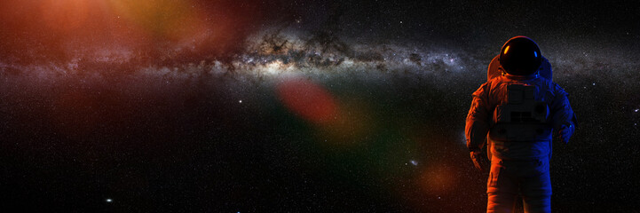 Wall Mural - standing astronaut in front of the beautiful milky way galaxy