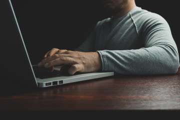 Aufkleber - Close up Man sitting laptop on a red wooden table. Beautiful black background
