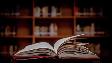 Poster - Stack of books in the library and blur bookshelf background