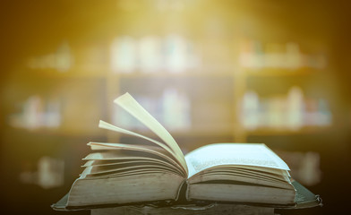 Poster - Stack of books in the library and blur bookshelf background