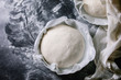 Process of making homemade bread. Fresh dough redy for baking on baked paper over black table with flour. Home bread baking. Photo series. Flat lay, space