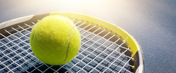 Close-up shots of tennis balls in tennis courts With a mesh as a blurred background And the light shining on the ground makes the image beautiful