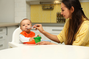 Canvas Print - Young mother feeding her little baby at home