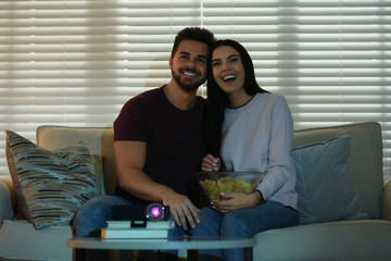 Poster - Young couple watching movie using video projector at home