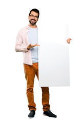 Handsome man with beard holding an empty placard