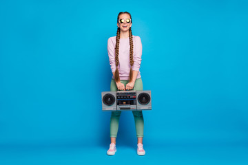 Sticker - Full length photo of positive cheerful youngster with braids girl hold cassette record boombox want retro party on rest relax wearing pink sweater sneakers isolated over blue color background