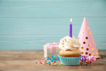 Composition With Birthday Cupcake On Wooden Table Against Light Blue Background. Space For Text