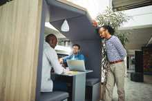 Smiling Group Of Diverse Businessmen Working In A Meeting Pod