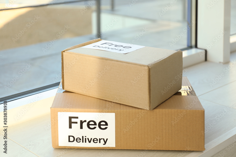 Parcels with sticker Free Delivery on window sill. Courier service - obrazy, fototapety, plakaty 