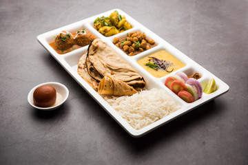 Wall Mural - Indian vegetarian Food Thali or Parcel food-tray with compartments in which Malai Kofta, chole, Dal tarka, dry aloo sabji, chapati and rice with sweet gulab jamun served