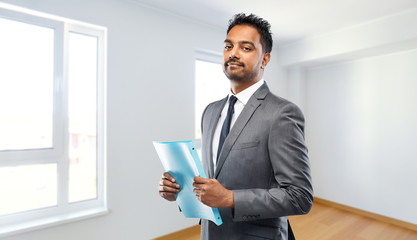 Sticker - real estate business and people concept - indian man realtor with folder over empty new apartment room background