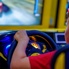 Wall Mural - Technology, gaming, entertainment and people concept - happy smiling boy in red t-shirt with playing car racing video game and steering wheel.