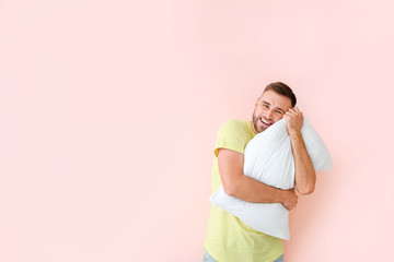 Canvas Print - Young man with pillow on color background