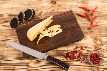 Wall Mural - Sliced cheese, sausage and bread on a wooden cutting board