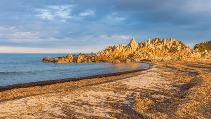 Wall Mural - Fantastic landscape, textured colorful rocks formation on the beach in Villasimius, Sardinia, Italy. Golden hour Holidays, the best beaches in Sardinia.