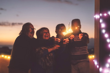 Seniors friends having fun celebrating holidays together outdoor - Happy older people enjoying party laughing on terrace at sunset time - Elderly lifestyle activity and culture event concept