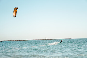 Wall Mural - Professional kiter rides on the waves, jumps on the sea.