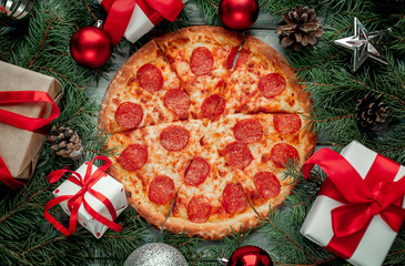 Christmas pepperoni pizza with Christmas decorations, gift, spruce, toys