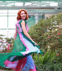 Wall Mural - beautiful red-haired girl in arranger where azalea blooms in a colorful flying dress