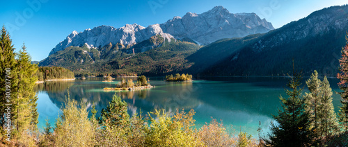 Panorama Image of Eibsee during autumn with the Zudspitze in the background and water reflections © Alex
