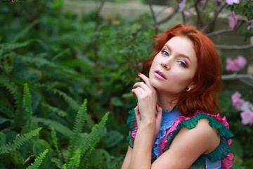 Wall Mural - beautiful red-haired girl in arranger where azalea blooms in a colorful flying dress