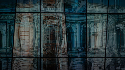 reflection of ancient architecture in the windows of the modern building