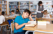© JackF - Upset tween boy reading in school library