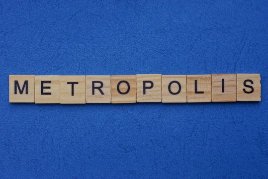 word metropolis made from brown wooden letters lies on a blue table