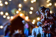 Christmas image, silhouette of shepherd with sheep, background with blur of the nativity scene of Bethlehem, with the Holy Family and small night lights around.
