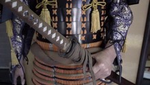Slowly Panning Across A Japanese Sword (katana) Held By A Man In A Full Body Suit Of Traditional Bushido (samurai) Armor