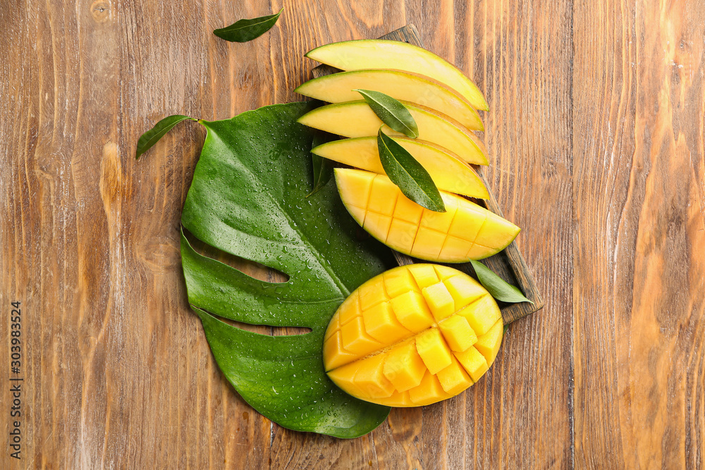 Cut mango fruit on wooden background