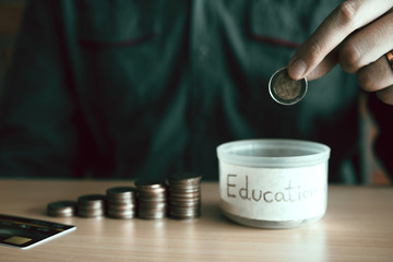 Wall Mural - Men are holding coins dropping to the money box with the concept of saving.