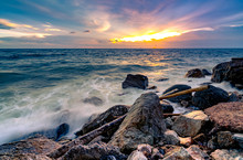 Ocean Water Splash On Rock Beach With Beautiful Sunset Sky And Clouds. Sea Wave Splashing On Stone At Sea Shore On Summer. Nature Landscape. Tropical Paradise Beach At Sunset. Rock Beach At Coast.