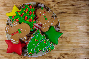 Wall Mural - Plate with tasty festive Christmas gingerbread cookies on wooden table. Top view