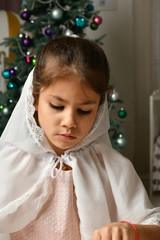 Wall Mural - girl in a white cape near the new year tree