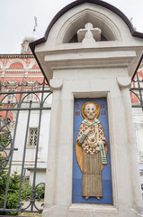 Wall Mural - Ceramic icons on the fence of the Temple of the Entry into the Church of the Blessed Virgin in Barashy. Bas-relief of St. Nicholas the Wonderworker.