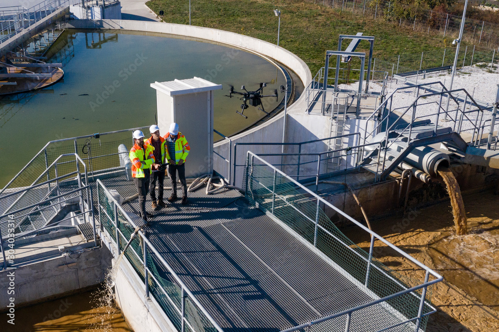 Engineers assesing waste treatment plant with drone - obrazy, fototapety, plakaty 